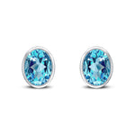 9ct White Gold Oval Natural Swiss Blue Topaz Rubover Stud Earrings — 9x7mm