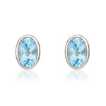 9ct White Gold Oval Natural Swiss Blue Topaz Rubover Stud Earrings — 6x4mm